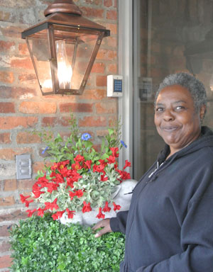 resident standing in front of red flowers