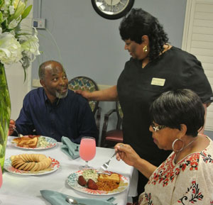 dining room staff member talking with residents while they dine